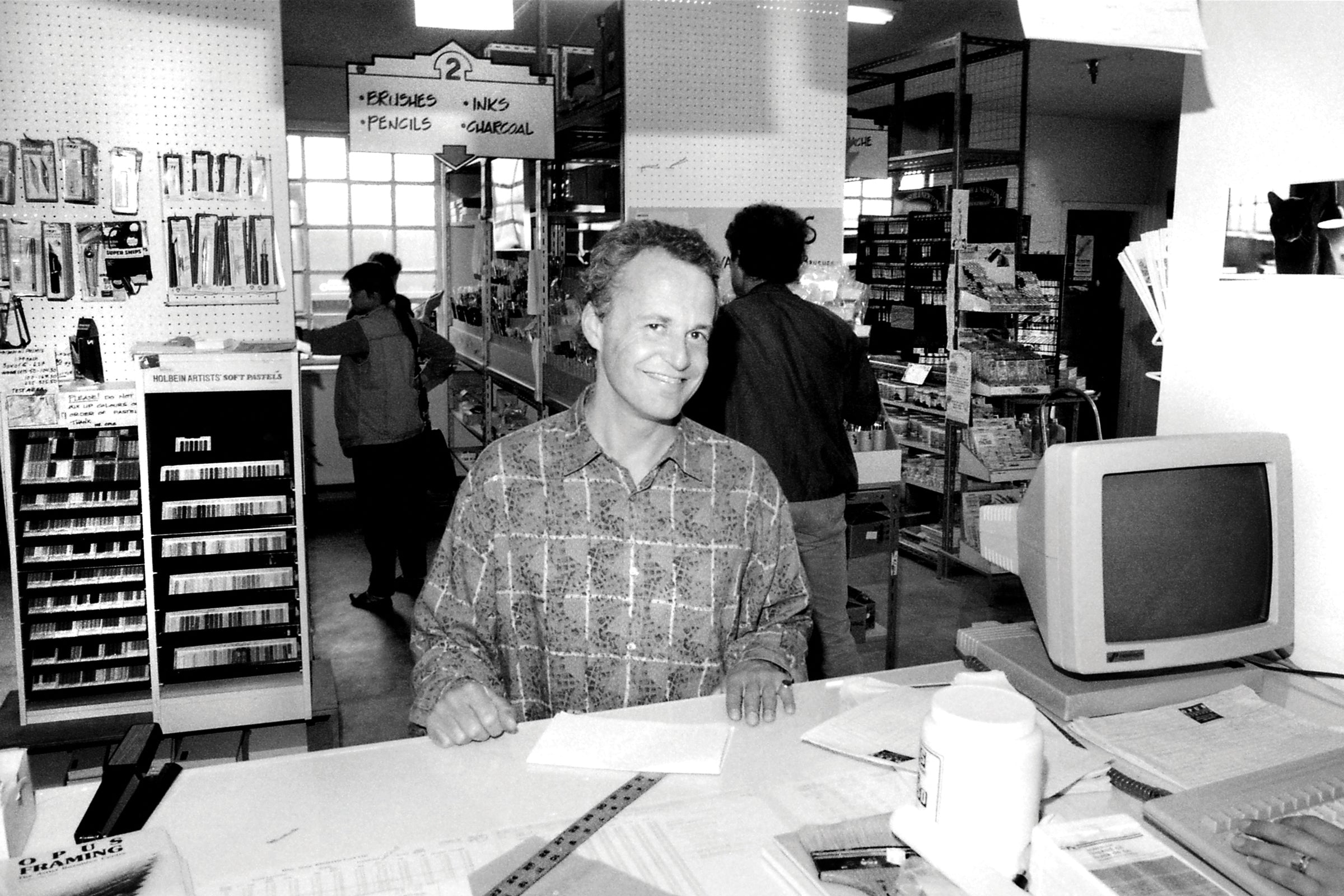 Black and white photograph of Opus Founder David van Berckel at the Flowmarts Granville Island location in 1987. 